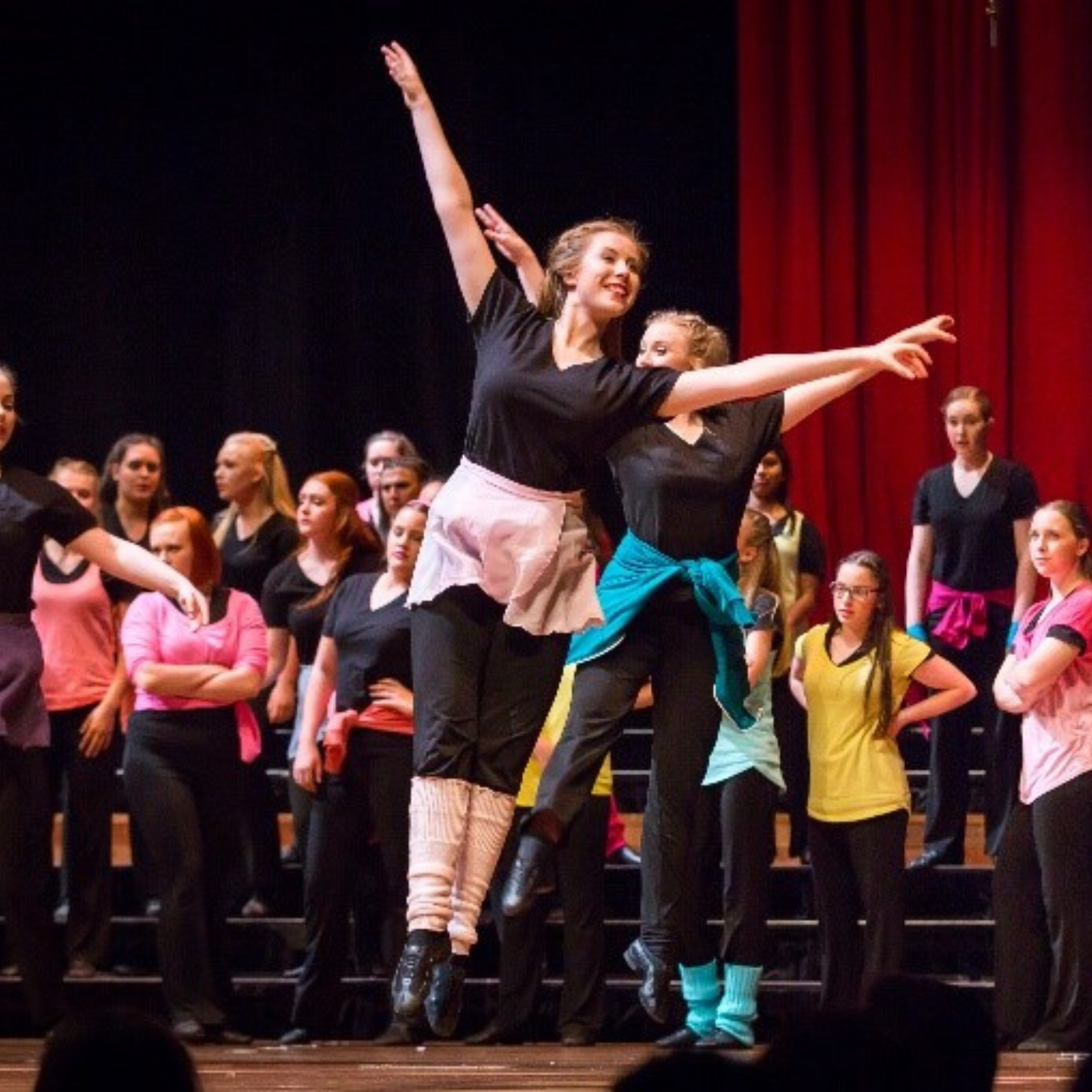 Grace jumps in the air with her arms up during a dance performance