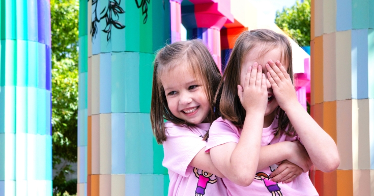 Two girls play hide and seek together