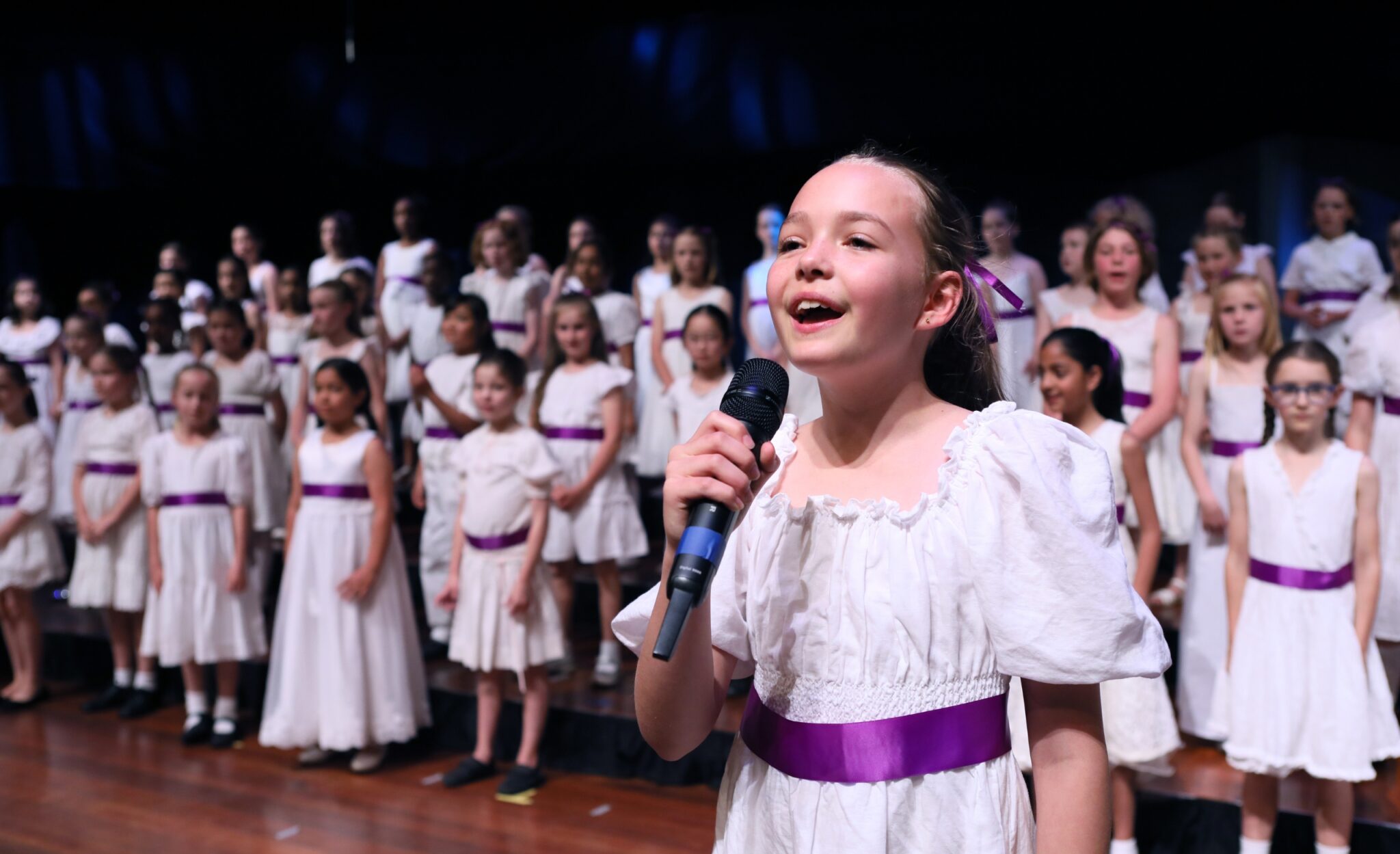 Girl sings on stage during a concert