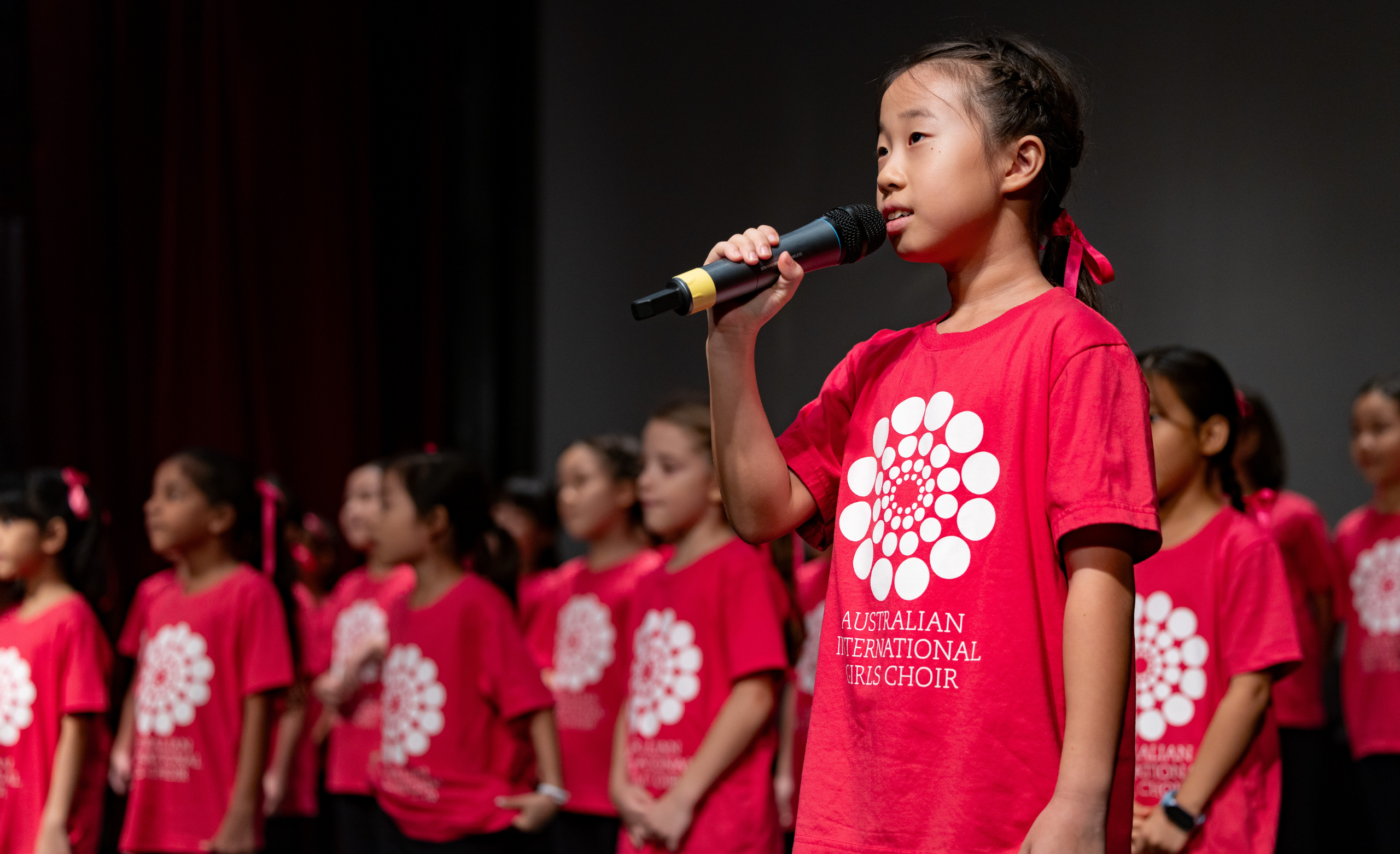 IGC chorister sings into a microphone on stage