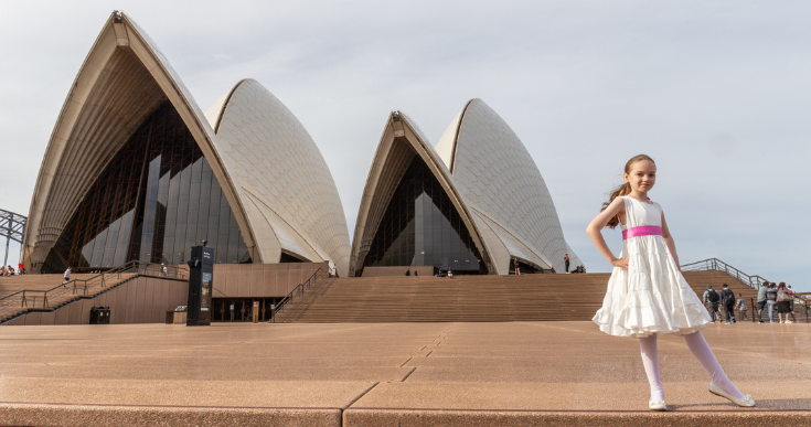 Young girl in white dress in front the Sydney Opera House